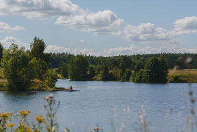 Scenic view of lake in forest against sky