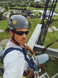 Portrait of mid adult man sitting on crane