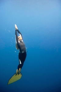 Mid adult woman swimming undersea