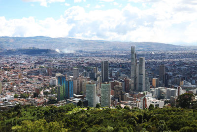 Aerial view of buildings in city against sky