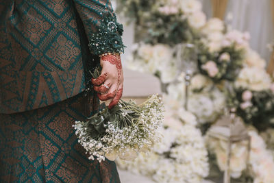 Midsection of woman holding flowering plant