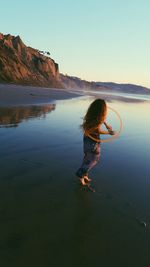 Boy standing in water against clear sky