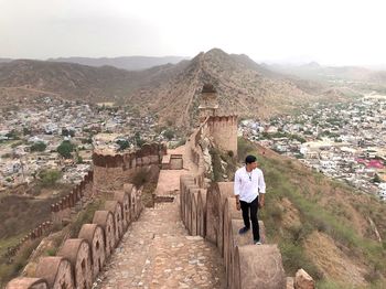 Rear view of woman looking at buildings against sky