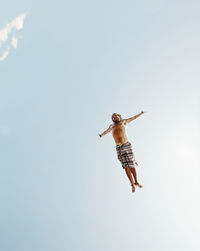Low angle view of man in mid-air against sky