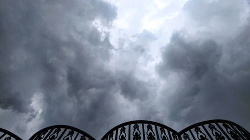 Low angle view of bridge against cloudy sky