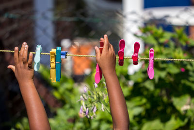 Cropped hands holding clothespins on clothesline