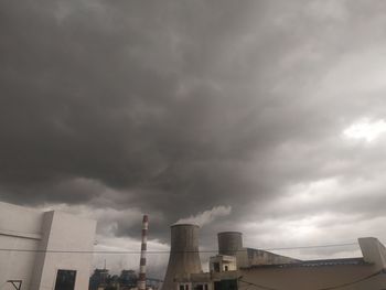 Low angle view of buildings against cloudy sky