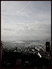 View of cityscape against cloudy sky