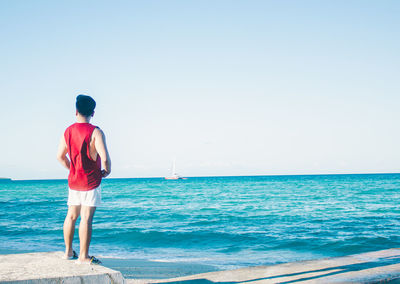 Rear view of man standing on beach