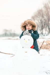 Low section of woman standing on snow covered field