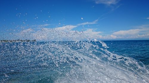 Wake in sea against blue sky