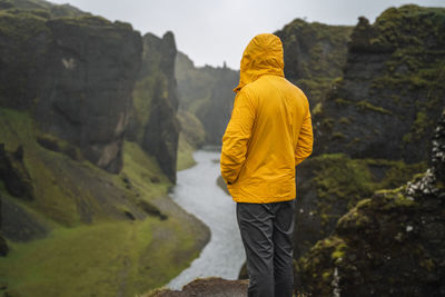 Rear view of man standing on rock