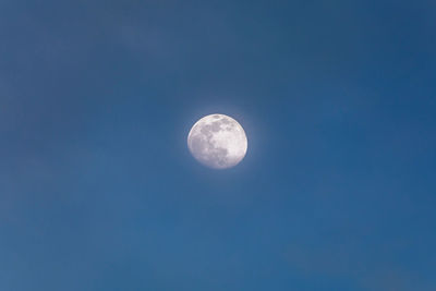 Low angle view of moon against clear blue sky