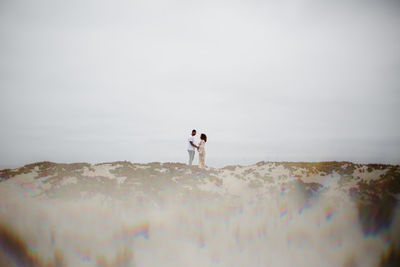 People standing on land against sky