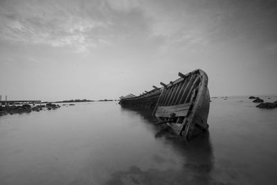 Abandoned built structure in sea against sky