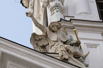 Low angle view of statue against historic building