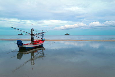 Fishing boat on sea against sky