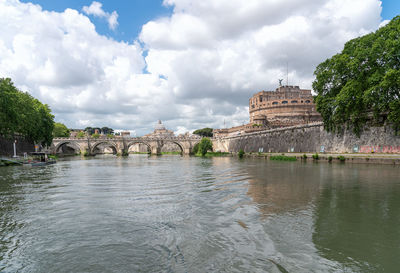 Arch bridge over river against buildings