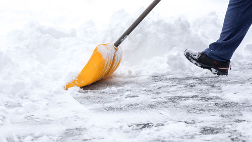 Man shoveling snow off of driveway in heavy snow storm 