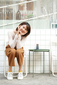 Portrait of smiling young woman sitting outdoors