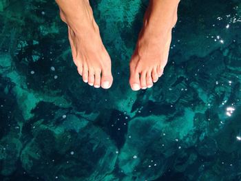 Low section of man sitting over water