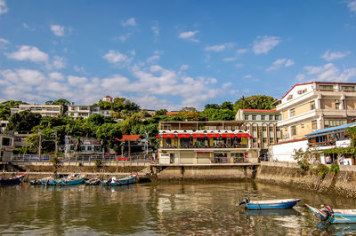 Boats in river with buildings in background