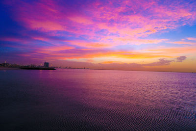 Scenic view of sea against dramatic sky during sunset