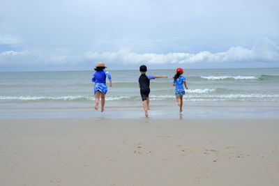 Happy children playing water on beach