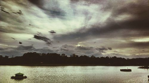 Scenic view of river against cloudy sky