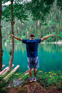 Rear view of woman standing in forest