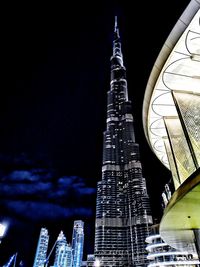 Low angle view of illuminated buildings against sky at night