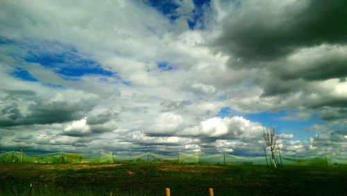 Scenic view of field against cloudy sky