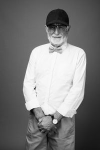 Portrait of man standing against black background