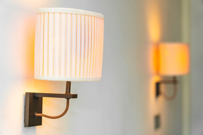 Close-up of electric lamp against wall at home