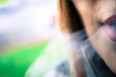 Cropped image of woman exhaling smoke