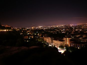 Illuminated cityscape against sky at night
