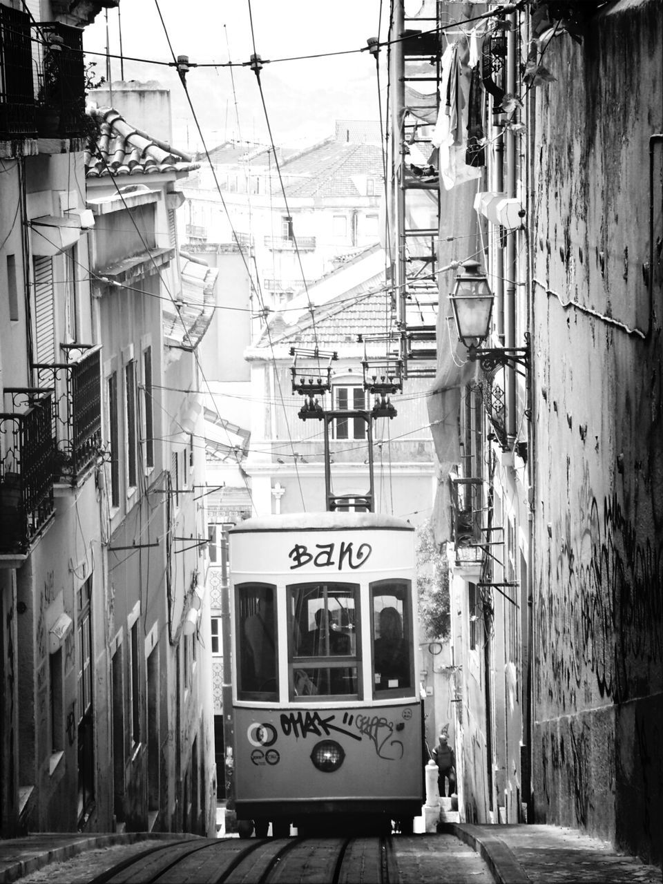 building exterior, architecture, built structure, transportation, street, power line, city, residential structure, residential building, incidental people, cable, the way forward, day, house, outdoors, building, mode of transport, road, town, electricity pylon