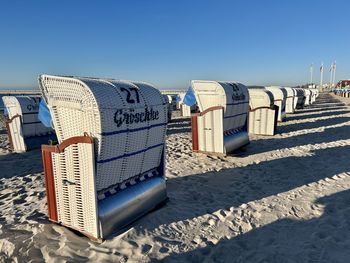 Low angle view of beach chair against clear sky