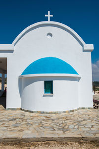 Traditional greek white chapel with a blue roof on the seaside. agioi anargyroi chapel, cyprus