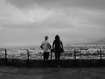 Silhouette of girl standing against cloudy sky