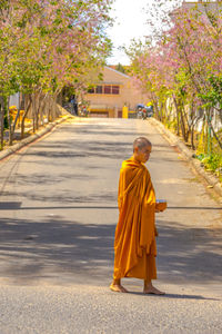 Full length of monk walking on footpath