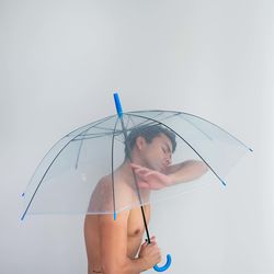 Portrait of woman with umbrella against clear sky