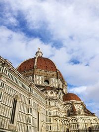Low angle view of duomo santa maria del fiore against cloudy sky