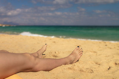 Low section of person relaxing on beach