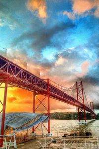 Bridge over sea against cloudy sky