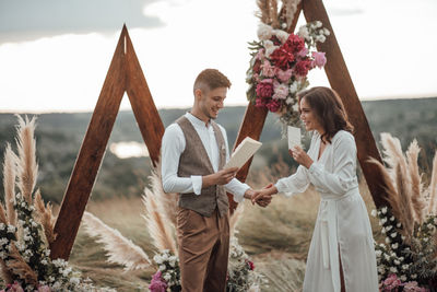 Friends standing against plants