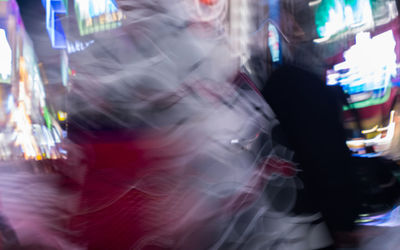 Blurred motion of people in illuminated city at night