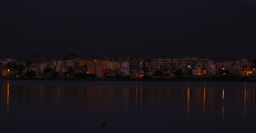 Illuminated cityscape against sky at night