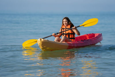 Portrait of woman kayaking in sea