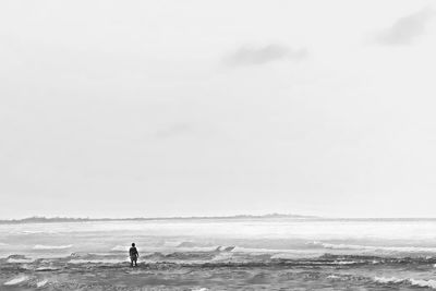 Man standing on beach against clear sky